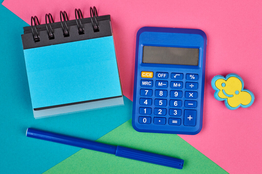 Une calculatrice et un stylo bleu et un bloc note bleu